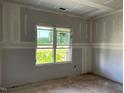 Bright bedroom features neutral walls, concrete flooring, and a window with backyard view at 178 Seahawk Way, Zebulon, NC 27597