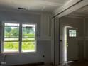 Bright living room features a large window overlooking the front yard and an open door at 178 Seahawk Way, Zebulon, NC 27597