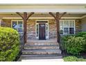 Inviting front porch with stone columns and steps leading to a wood front door at 204 Plantation Dr, Youngsville, NC 27596