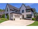 Beautiful exterior view of a two-story home with white painted brick, black roof, manicured landscaping and a driveway at 2114 Cowper Dr, Raleigh, NC 27608