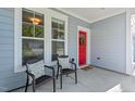 Welcoming front porch with stylish seating, perfect for enjoying the outdoors, has a bright red front door at 217 Macy Grove Dr, Chapel Hill, NC 27517