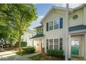 Charming exterior of a townhome with a red door, complemented by neat landscaping and natural sunlight at 2261 Plum Frost Dr, Raleigh, NC 27603