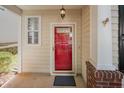 Close-up of a red front door with visible house number, light fixture, and brick accents at 2261 Plum Frost Dr, Raleigh, NC 27603