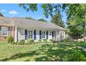 Inviting home featuring a well-kept lawn, vibrant blue shutters, and a welcoming entryway at 2617 Cottage Cir, Raleigh, NC 27613