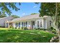 Attractive home exterior with blue shutters, lush landscaping, and a neatly maintained lawn at 2617 Cottage Cir, Raleigh, NC 27613