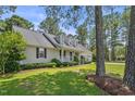 Traditional ranch home with dormer windows, attached two-car garage, lush landscaping and mature shade trees at 3109 Gold Dust Ln, Willow Springs, NC 27592