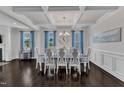 Elegant dining room with coffered ceiling, chandelier, and a large table with eight chairs at 326 S Parliament Way, Clayton, NC 27520