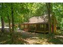 Cozy log cabin exterior surrounded by lush greenery and mature trees at 3263 S Jim Minor Rd Rd, Haw River, NC 27258