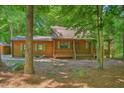 Charming log cabin exterior with green shutters is nestled among the trees at 3263 S Jim Minor Rd Rd, Haw River, NC 27258