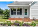 Inviting front porch with hanging plants and decorative wreath, offering a warm welcome at 3831 Abattoir Rd, Angier, NC 27501