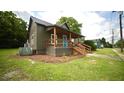 Side view of home shows metal roof, covered porch, and green siding at 416 Everett St, Burlington, NC 27215