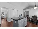 Bright kitchen with gray cabinets, center island, and hardwood flooring open to the living spaces at 4505 Woodlawn Dr, Raleigh, NC 27616