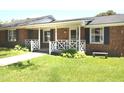 Lovely brick home featuring a charming front porch and beautifully manicured front lawn at 521 S Lombard St, Clayton, NC 27520