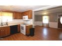 Bright kitchen with wood cabinets, laminate counters, open to adjacent dining area at 521 S Lombard St, Clayton, NC 27520