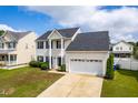 Charming two-story home with attached two-car garage, well-maintained lawn, and manicured shrubbery at 5309 Neuse Wood Dr, Raleigh, NC 27616