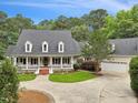 Beautiful home with a large front porch, mature trees, well-kept lawn, and an extended driveway leading to a garage at 5317 Moonflower Ct, Holly Springs, NC 27540