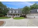 Inviting home with a classic front porch, green lawn, and curved driveway leading to a detached garage and additional parking at 5317 Moonflower Ct, Holly Springs, NC 27540