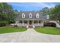 Lovely home with a wide front porch, tidy landscaping, and a concrete driveway leading to an attached garage at 5317 Moonflower Ct, Holly Springs, NC 27540