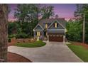 Charming two-story home with gray siding, stone accents, illuminated at dusk at 5504 Earle Road, Raleigh, NC 27606