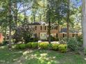 Traditional brick home with a well-maintained lawn and mature trees providing shade at 5617 Partridge Ln, Raleigh, NC 27609