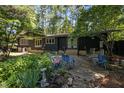 Backyard patio with table and chairs perfect for outdoor dining amongst mature landscaping and lush greenery at 5836 Sandstone Dr, Durham, NC 27713