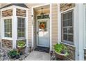 Close-up of the front door with decorative wreath and well-kept potted plants enhancing the entrance at 6008 River Lake Cir, Raleigh, NC 27604