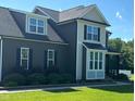 Two-story home with dark siding, gray shingled roof, green grass, and landscaping at 644 Wall Rd, Wendell, NC 27591