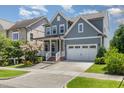 Beautiful exterior of a well-manicured home, showcasing a two-car garage and inviting front porch with colorful flowers at 664 Old Dairy Dr, Wake Forest, NC 27587