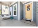 Inviting front porch featuring a cozy swing, complemented by stylish decor and a vibrant yellow front door at 664 Old Dairy Dr, Wake Forest, NC 27587