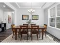 Elegant dining room featuring a classic chandelier, wood table with seating for six, and tray ceiling at 7301 Villoria Ln, Raleigh, NC 27617