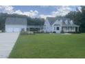 Charming home featuring a lush green lawn, two-car garage, and connecting walkway at 759 Wheeler Dr, Angier, NC 27501