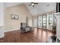 Bright living room with hardwood floors, vaulted ceiling, large windows, and a comfortable recliner, offering a relaxing space at 80 Scarlet Bell Dr, Youngsville, NC 27596