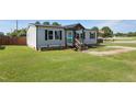 Inviting home features a cozy porch with an American flag, a well-maintained lawn and fresh landscaping at 10 Wilders Ln, Louisburg, NC 27549