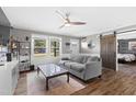 Inviting living room boasts a comfortable gray sofa, large windows, and a modern ceiling fan at 10 Wilders Ln, Louisburg, NC 27549