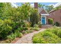 Brick home with a garden walkway leading to a charming blue front door and manicured landscaping at 1007 W Markham Ave, Durham, NC 27701