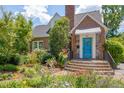 Charming brick home featuring beautiful landscaping and an inviting blue front door entrance at 1007 W Markham Ave, Durham, NC 27701