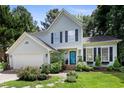 Two story home with light blue siding, dark shutters, and a bright blue front door at 109 Crane Meadow Pl, Chapel Hill, NC 27514