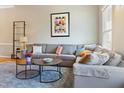 A cozy living room featuring a plush gray sectional sofa, modern decor, and a stylish blue rug at 109 Crane Meadow Pl, Chapel Hill, NC 27514