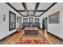 Bright living room boasts hardwood floors, fireplace, coffered ceilings and elegant chandelier at 118 N 7Th St, Smithfield, NC 27577