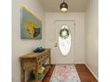 Welcoming entryway with hardwood floors, a decorative rug, stylish table, and an oval window front door at 1487 Kentucky Ave, Sanford, NC 27332