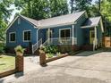 Cozy home boasting vibrant blue siding, pristine landscaping, a metal roof, and inviting white porch at 1487 Kentucky Ave, Sanford, NC 27332