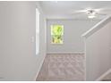 Bright bonus room featuring neutral carpeting, a ceiling fan, and natural light from large windows at 150 Ivy Bank Dr, Angier, NC 27501