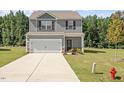 Inviting two-story home featuring a well-maintained lawn, driveway, and a classic facade at 154 Taverners Ln, Angier, NC 27501