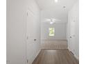 Bright hallway leading to a living area with neutral carpet and a ceiling fan at 154 Taverners Ln, Angier, NC 27501