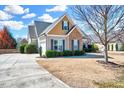 Charming two-story home with stone accents, a well-manicured lawn, and a driveway leading to the garage at 1624 Struble Cir, Willow Springs, NC 27592