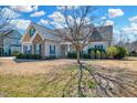 Traditional home with a covered front porch, stone accents, tidy landscaping, and a well-maintained front lawn at 1624 Struble Cir, Willow Springs, NC 27592