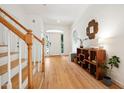 Bright foyer with hardwood floors, white walls, and a staircase with wood railing at 219 W Columbia Pl, Chapel Hill, NC 27516