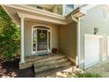 Inviting front entrance with stone steps leading to an arched front door with yellow wreath at 219 W Columbia Pl, Chapel Hill, NC 27516