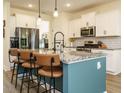 Beautiful kitchen island features granite counters, stylish pendant lighting, and seating for casual dining at 221 Stella Way, Cameron, NC 28326