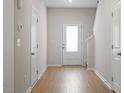 Bright hallway featuring wood floors and multiple doors, leading to various rooms at 224 Ivy Bank Dr, Angier, NC 27501